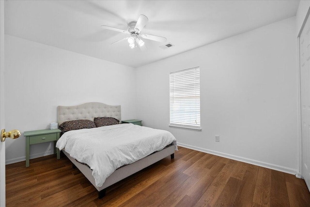 bedroom with a ceiling fan, baseboards, visible vents, and wood finished floors