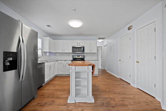 kitchen featuring white cabinetry, butcher block counters, appliances with stainless steel finishes, and dark wood-type flooring
