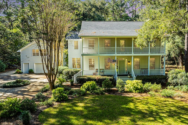 view of front of home featuring a front lawn, a garage, and covered porch