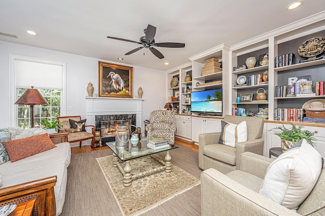 living room with a fireplace, ceiling fan, and hardwood / wood-style flooring