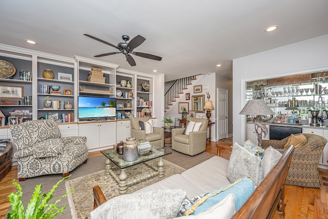 living room with ceiling fan and light hardwood / wood-style flooring