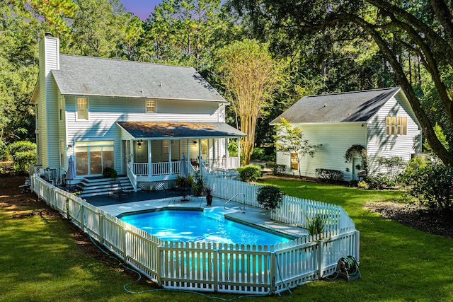 back of house featuring a yard and a swimming pool side deck