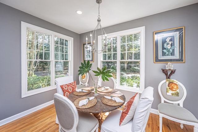 dining space featuring light wood-type flooring, a chandelier, and a wealth of natural light