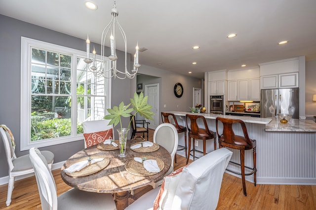 dining area featuring a notable chandelier, light hardwood / wood-style flooring, and plenty of natural light