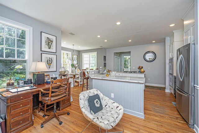 office space with light hardwood / wood-style flooring and sink