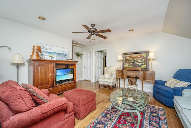 living room with ceiling fan, lofted ceiling, and light hardwood / wood-style floors