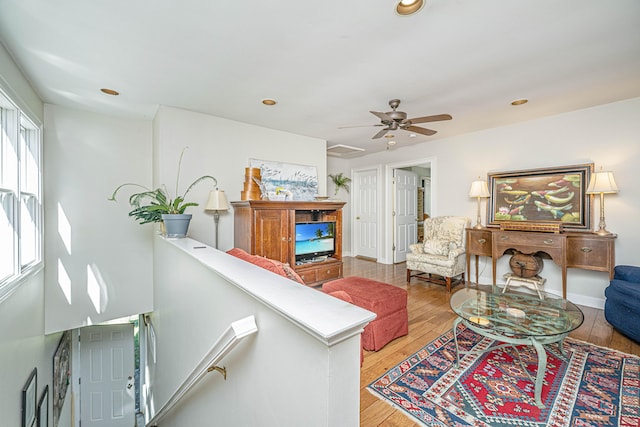 living room with wood-type flooring and ceiling fan