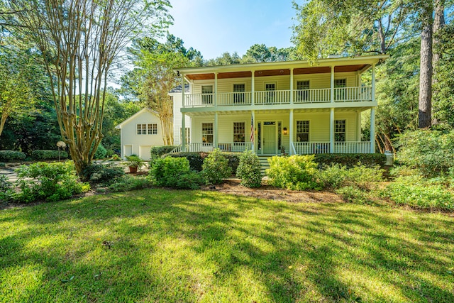 back of property featuring a lawn, a balcony, and a porch