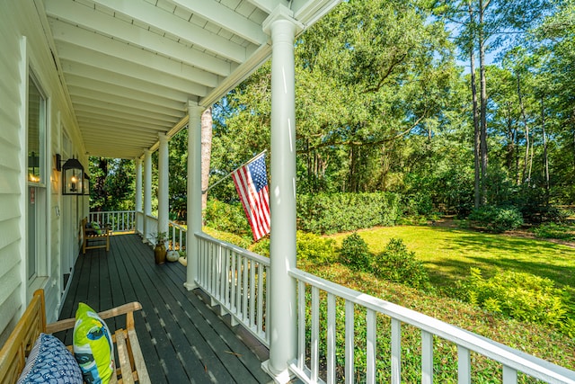 deck featuring a yard and covered porch