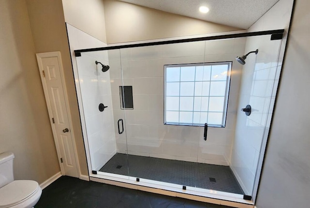 bathroom featuring a textured ceiling, toilet, lofted ceiling, and walk in shower