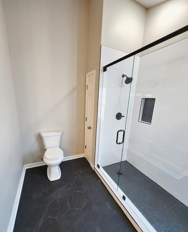 bathroom with toilet and a shower with door