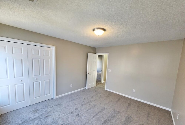 unfurnished bedroom with a closet, light colored carpet, and a textured ceiling