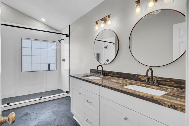 bathroom with vanity, tile patterned floors, vaulted ceiling, tiled shower, and a textured ceiling