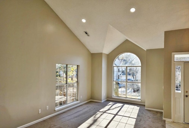 carpeted entryway with high vaulted ceiling