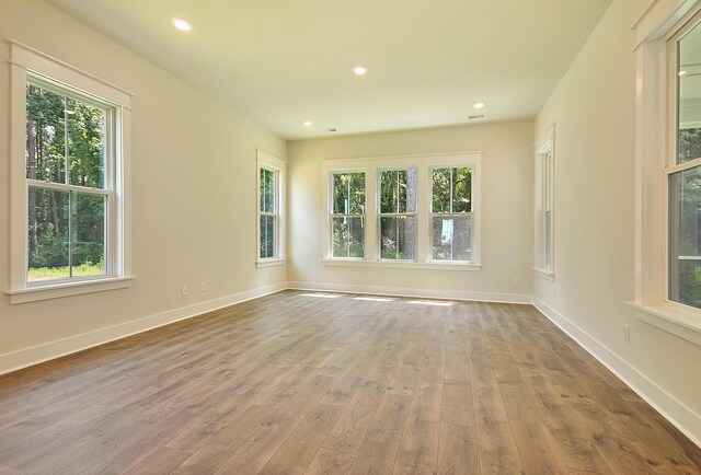 unfurnished room featuring recessed lighting, baseboards, and wood finished floors