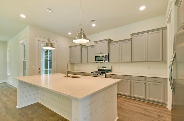 kitchen with gray cabinets, appliances with stainless steel finishes, decorative backsplash, and a sink