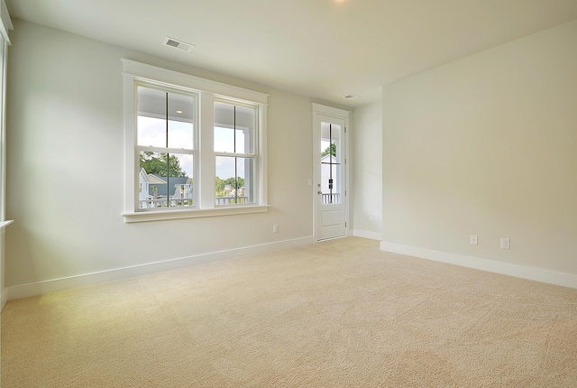 unfurnished room with carpet flooring, baseboards, and visible vents