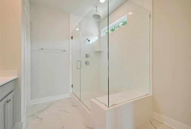 full bath with baseboards, marble finish floor, vanity, and a shower stall