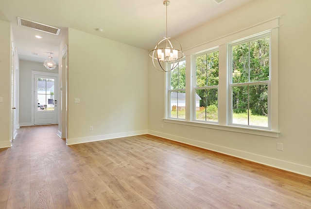 unfurnished dining area featuring visible vents, baseboards, a notable chandelier, and light wood-type flooring
