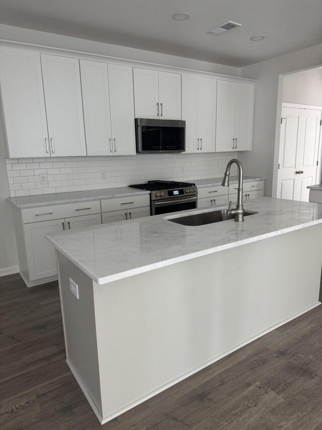 kitchen featuring white cabinets, a kitchen island with sink, sink, and appliances with stainless steel finishes