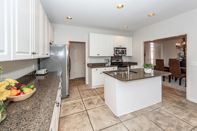 kitchen featuring dark stone countertops, recessed lighting, a sink, stainless steel appliances, and white cabinets