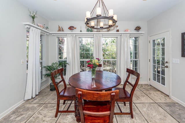 dining space featuring a chandelier, a healthy amount of sunlight, and baseboards