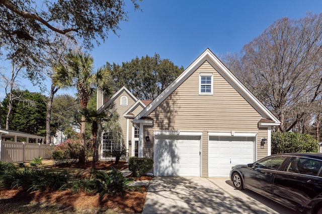 traditional-style house with a garage, a chimney, driveway, and fence