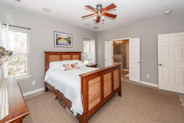 bedroom featuring connected bathroom, visible vents, baseboards, and ceiling fan