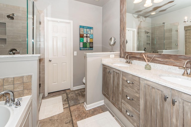 bathroom featuring double vanity, a shower stall, a garden tub, and a sink