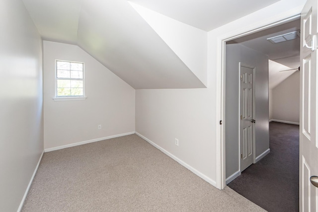 additional living space with vaulted ceiling, carpet flooring, baseboards, and visible vents