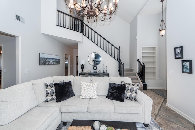 living room with stairway, baseboards, visible vents, a high ceiling, and a chandelier