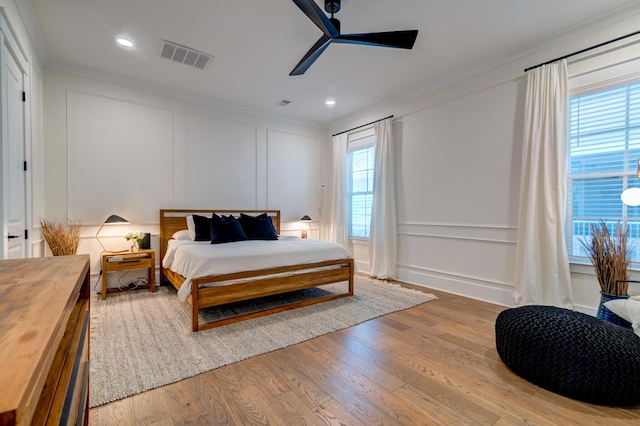 bedroom with crown molding, ceiling fan, and light hardwood / wood-style flooring