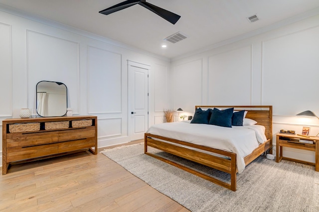 bedroom featuring ornamental molding, ceiling fan, and light wood-type flooring