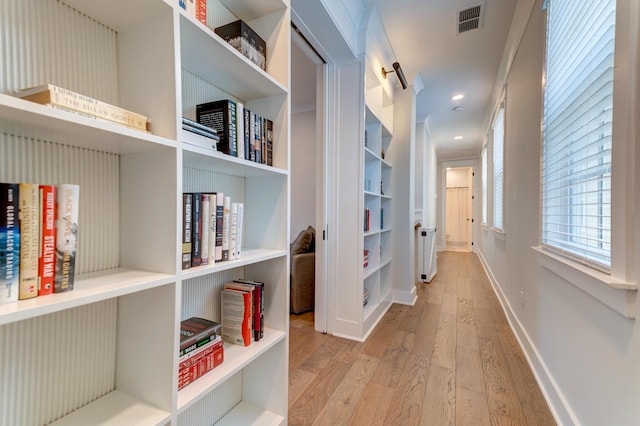 corridor featuring radiator and light hardwood / wood-style flooring