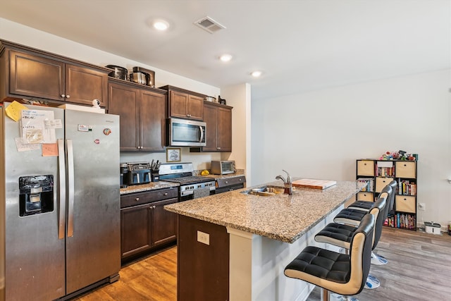 kitchen with visible vents, a sink, light wood-style floors, and appliances with stainless steel finishes