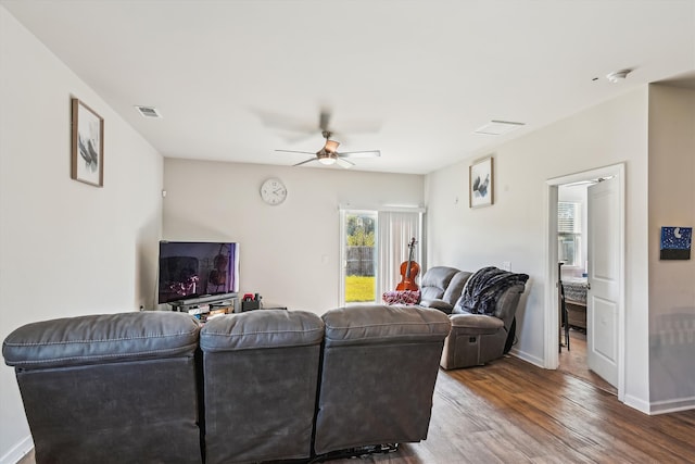 living area with wood finished floors, visible vents, baseboards, and ceiling fan