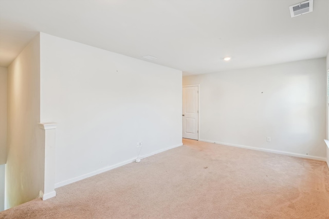 unfurnished room with baseboards, visible vents, and light colored carpet