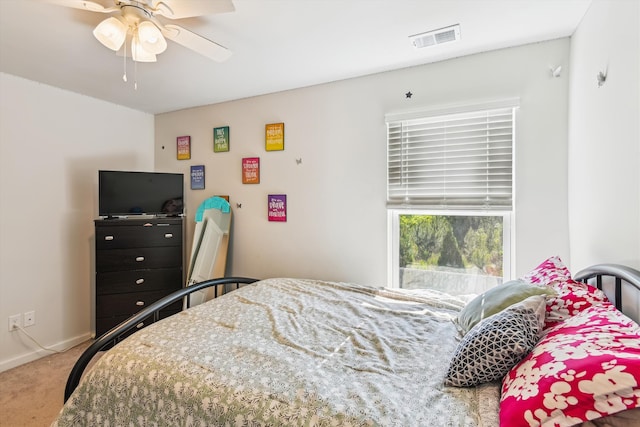 carpeted bedroom with visible vents, baseboards, and ceiling fan