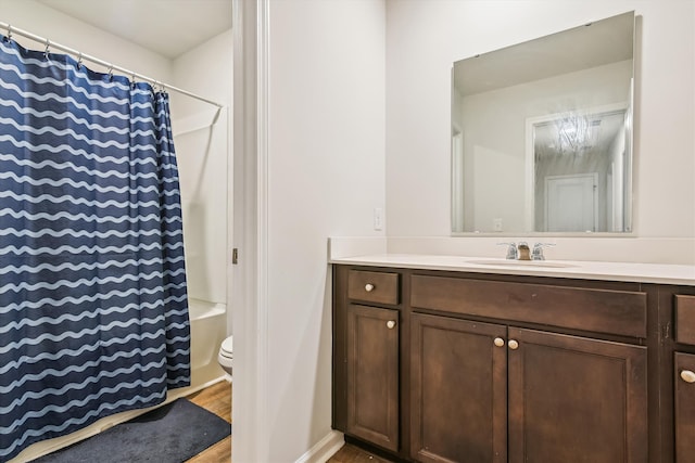 bathroom featuring curtained shower, wood finished floors, toilet, and vanity