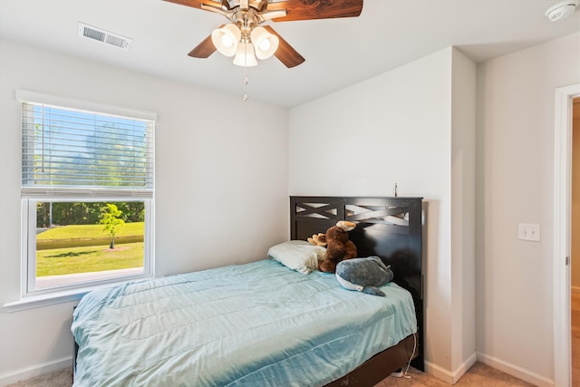 carpeted bedroom with ceiling fan, baseboards, and visible vents