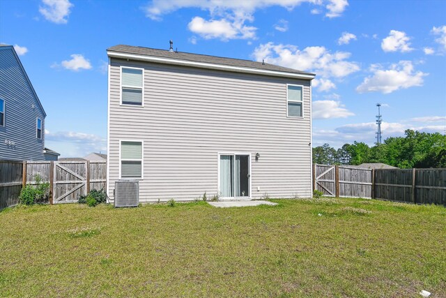 back of house with a fenced backyard, a gate, a yard, and central AC unit