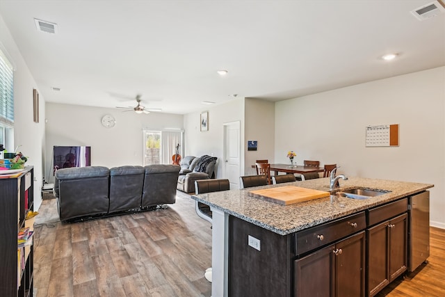 kitchen featuring wood finished floors, visible vents, a sink, and ceiling fan