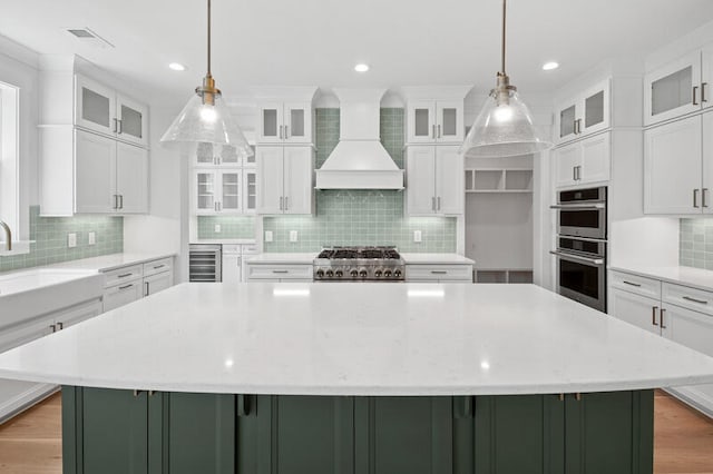 2006 Riverbend Dr, Charleston, SC 29412 - kitchen with premium range hood, double oven, a spacious island, tasteful backsplash, and recessed lighting
