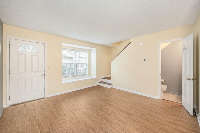 foyer featuring light hardwood / wood-style floors and a textured ceiling