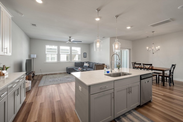 kitchen with sink, dark hardwood / wood-style floors, a kitchen island with sink, stainless steel dishwasher, and gray cabinetry