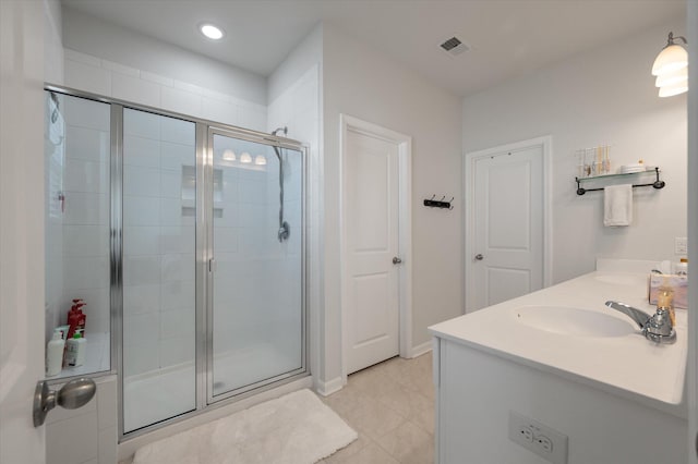 bathroom featuring vanity, a shower with shower door, and tile patterned flooring