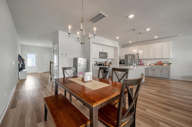 dining room with a notable chandelier and light hardwood / wood-style flooring