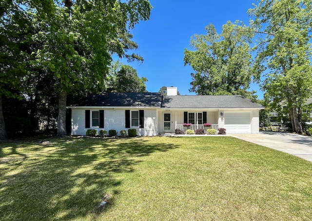 ranch-style home featuring covered porch, concrete driveway, an attached garage, a front yard, and a chimney