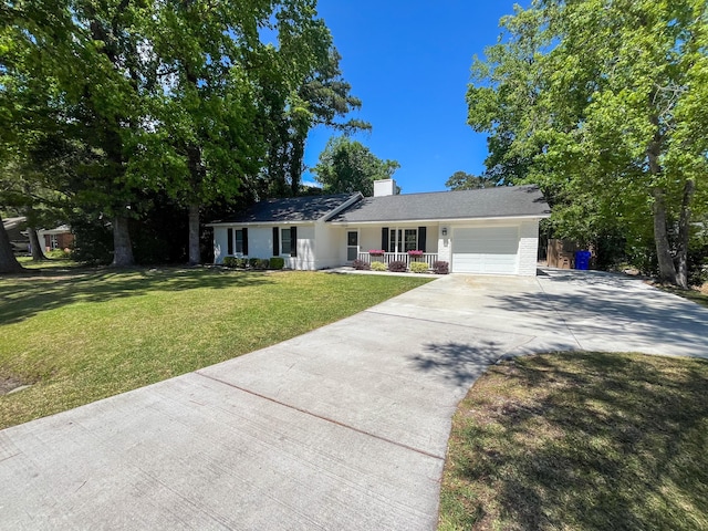 ranch-style house featuring a porch, concrete driveway, a garage, a front yard, and brick siding