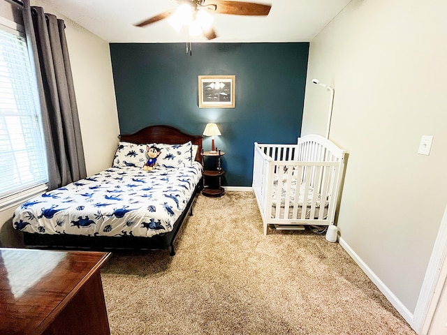 carpeted bedroom with baseboards and ceiling fan